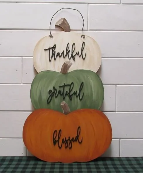Decorated stacked pumpkin door hanger.